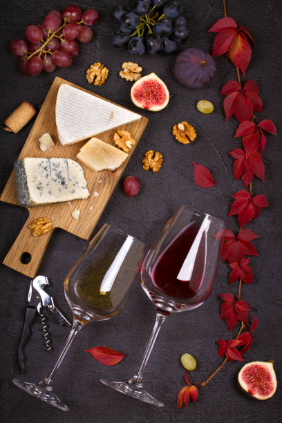 istock Red and white wine with cheese plate. Wine glasses with cheese,  grapes, figs and nuts. 874711220