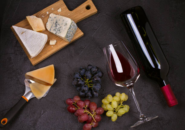 istock Red and white wine with cheese plate. Wine glasses with cheese,  grapes, figs and nuts. 874711466