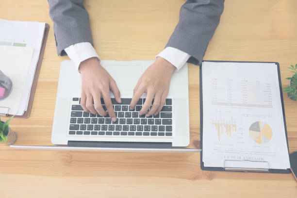 istock Business using laptop computer hand typing keyboard on business office. 874716148