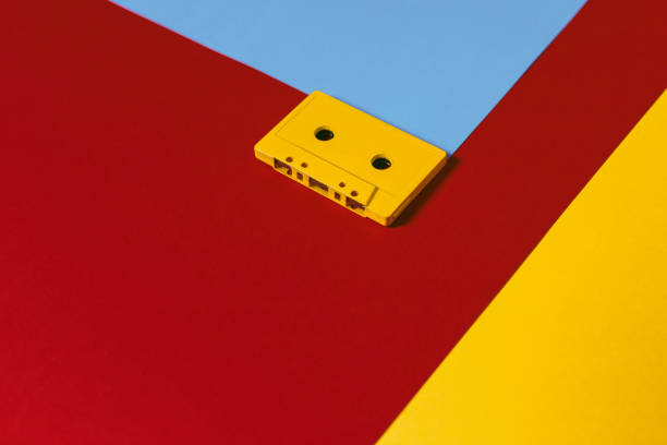 istock Yellow Audio Cassette Tapes On Colored Background, Top View. Creative Concept Of Retro Technology 874716154