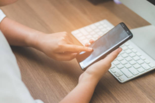 istock The worker woman touching screen on smart phone blurred image 874716972