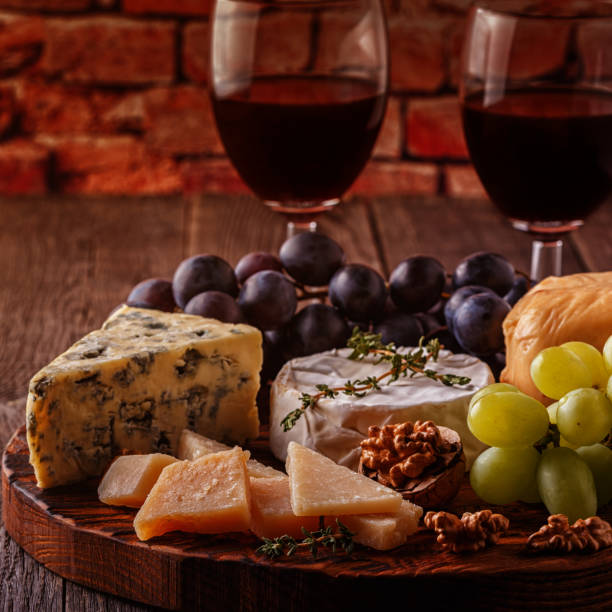 istock Cheese, nuts, grapes and red wine on wooden background 874722748