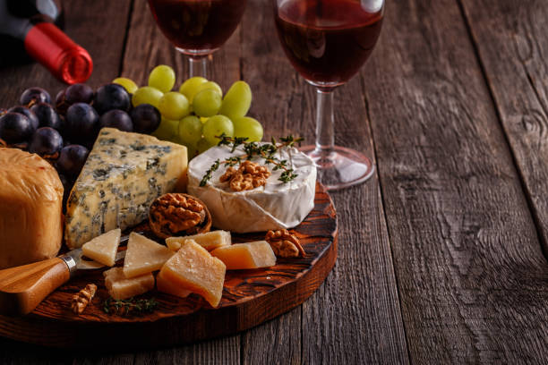 istock Cheese, nuts, grapes and red wine on wooden background 874722764