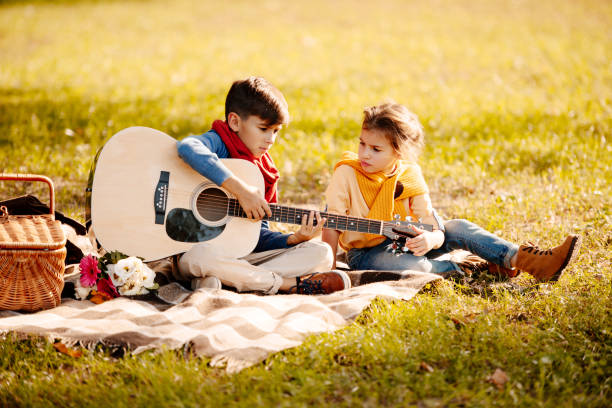 istock Children with guitar in park 874724770