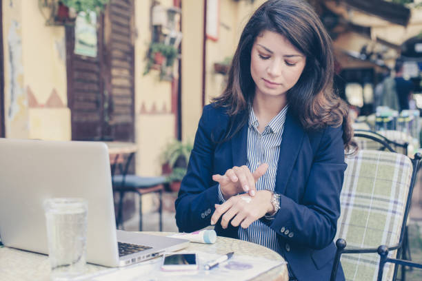 istock Young woman at cafe using hand cream. 874727260