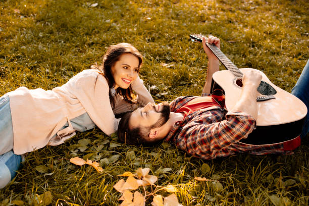 istock Couple lying on grass with guitar 874727464