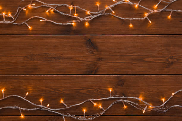 istock Christmas lights border on wood background 874728134
