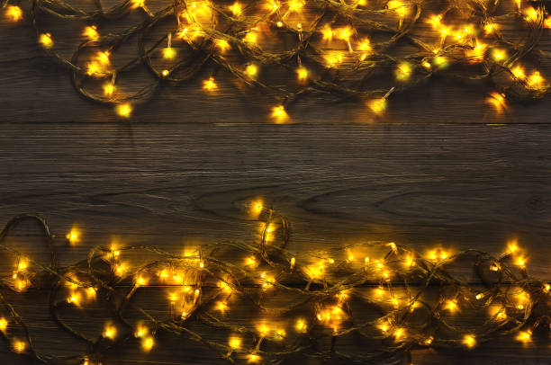 istock Christmas lights border on grey wooden background 874728306