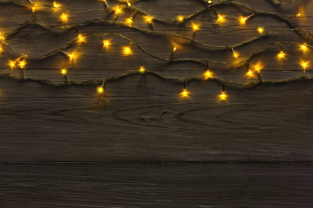 istock Christmas lights border on grey wooden background 874728358