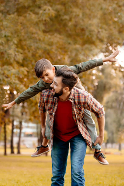 istock Father giving son piggyback ride 874735110