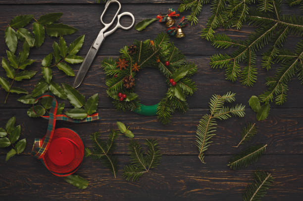 istock Handmade xmas wreath. Fir, leaves, scissors on rustic background 874735550
