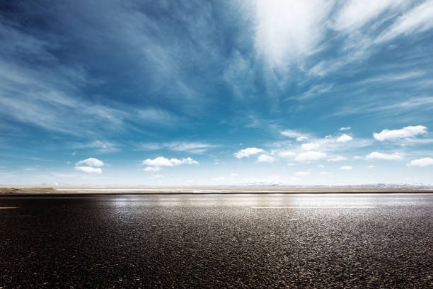 istock empty asphalt road with snow mountains in blue cloud sky 874735664