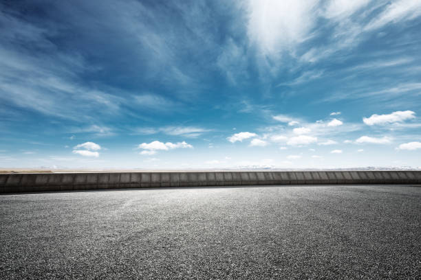 istock empty asphalt road with snow mountains in blue cloud sky 874735914