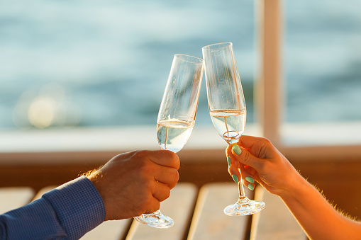 Happy couple drinks champagne on a yacht