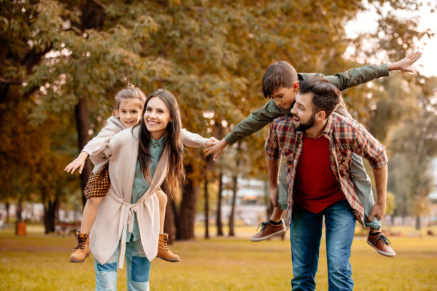 istock Parents giving children piggyback ride 874738380