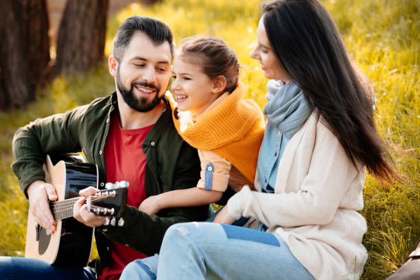 istock Young man playing guitar with family 874741306