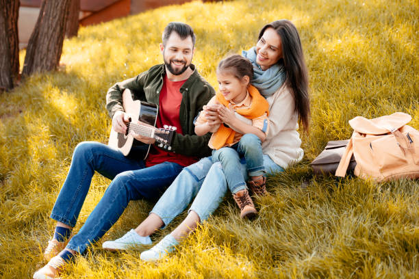 istock Young man playing guitar with family 874741500