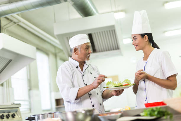istock Chef teaching a trainee to prepare asian food 874742178