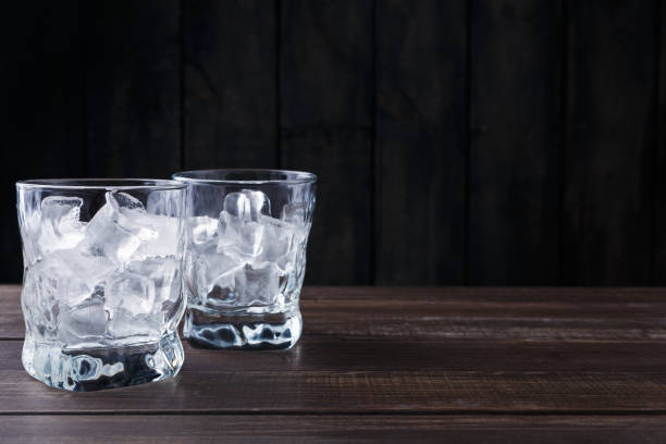 istock Glasses with ice cubes on dark background 874750372