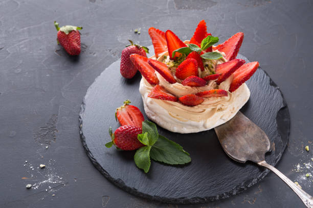 istock Anna Pavlova cake with strawberry on black background 874752908