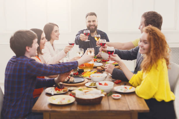 istock People say cheers clink glasses at festive table dinner party 874754292