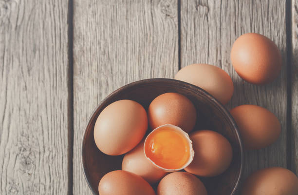 istock Fresh brown eggs in bowl on wood background 874760370