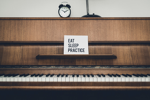 message on a piano: eat sleep practice. strength piano lessons.