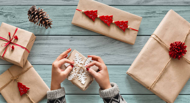 istock Woman's hands wrapping christmas holiday present with craft twin 874767738