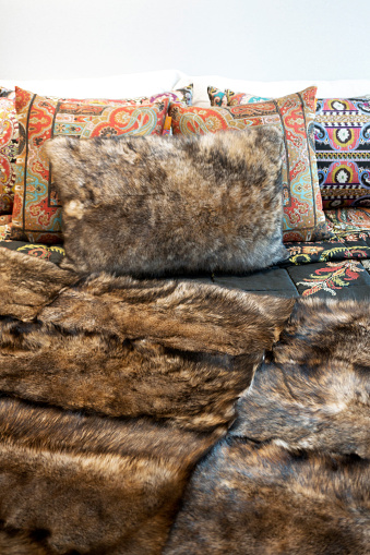 Fur pillows and coverlet on bed , winter decoration