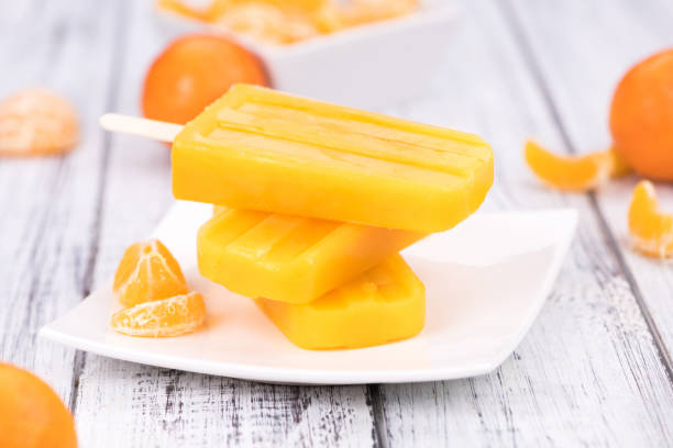 istock Wooden table with homemade Tangerine Popsicles 874775688