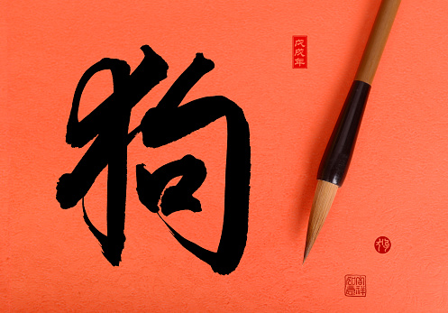 Chinese traditional brush with calligraphy meaning:dog,red stamps mean: good bless for new year,2018 is year of the dog