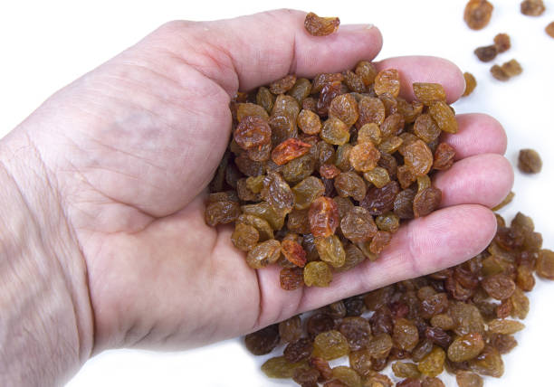 istock Sweet raisins in the hand on white background 874780720