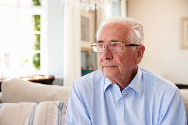 istock Senior Man Sitting On Sofa At Home Suffering From Depression 874788316