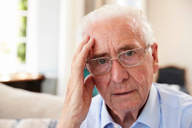 istock Portrait Of Senior Man Sitting On Sofa Suffering From Depression 874788336
