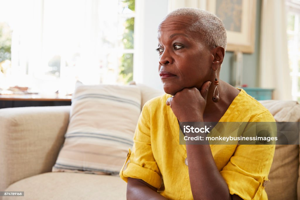 Haute femme assise sur le canapé à la maison souffrant de dépression - Photo de Troisième âge libre de droits