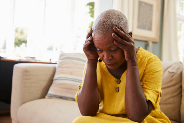 istock Senior Woman Sitting On Sofa At Home Suffering From Depression 874789280