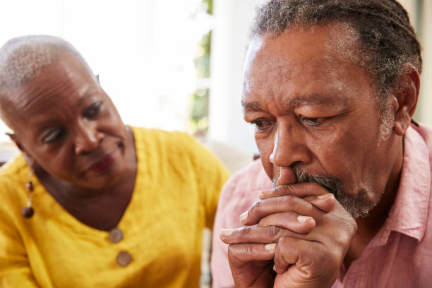 senior mujer consolando a hombre con depresión en el hogar - senior adult african descent men black fotografías e imágenes de stock