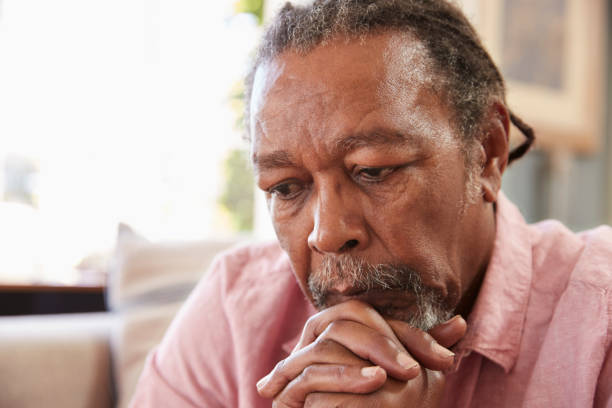 istock Senior Man Sitting On Sofa At Home Suffering From Depression 874791648