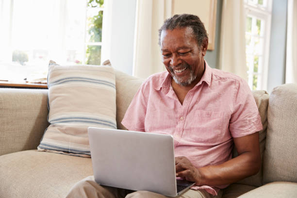 istock Senior Man Sitting On Sofa Using Laptop At Home Together 874791754