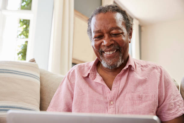 istock Senior Man Sitting On Sofa Using Laptop At Home Together 874791842