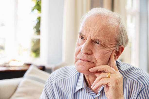 istock Senior Man Sitting On Sofa At Home Suffering From Depression 874791954