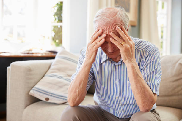 istock Senior Man Sitting On Sofa At Home Suffering From Depression 874792012