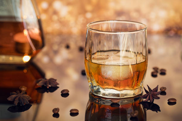 istock Cognac or liqueur, coffee beans and spices on a glass table. 874792912