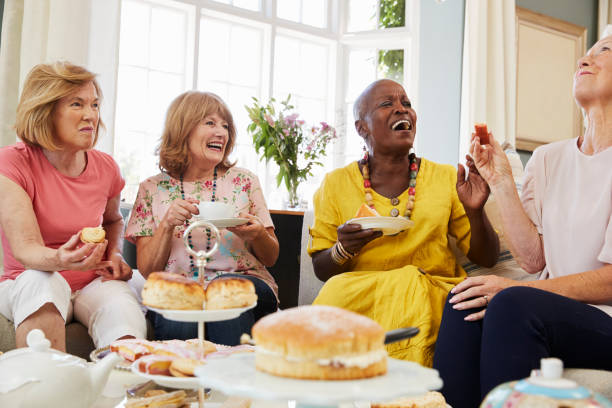 Senior Female Friends Enjoying Afternoon Tea At Home Together Senior Female Friends Enjoying Afternoon Tea At Home Together afternoon tea stock pictures, royalty-free photos & images