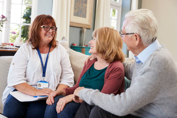 istock Female Support Worker Visits Senior Couple At Home 874793938