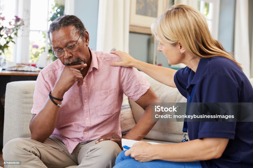 Support Worker Visits Senior Man Suffering With Depression Dementia Stock Photo