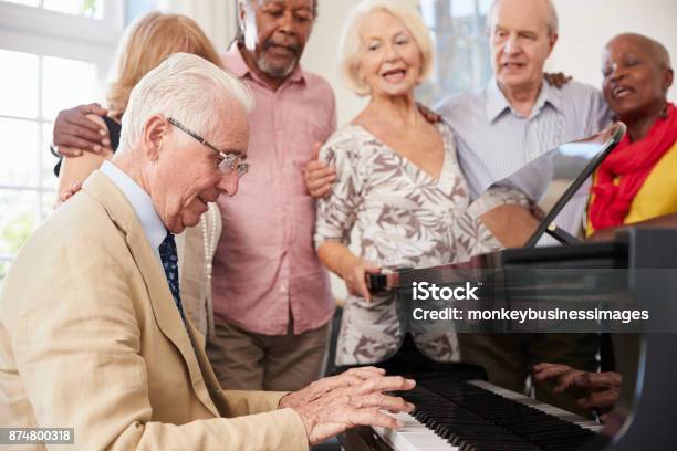 Gruppe Von Senioren Stehen Von Piano Und Gemeinsames Singen Stockfoto und mehr Bilder von Alter Erwachsener