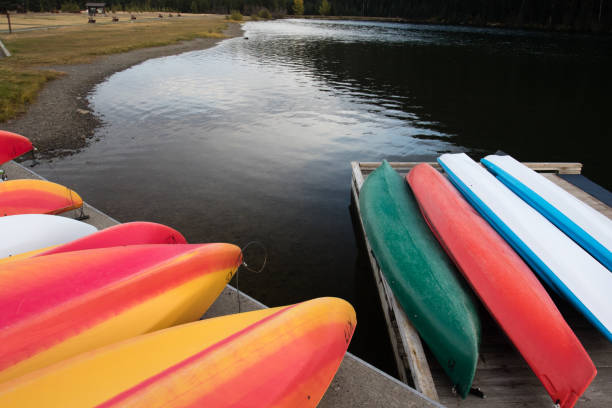 istock Colorful kayaks on a lake shore 874800608