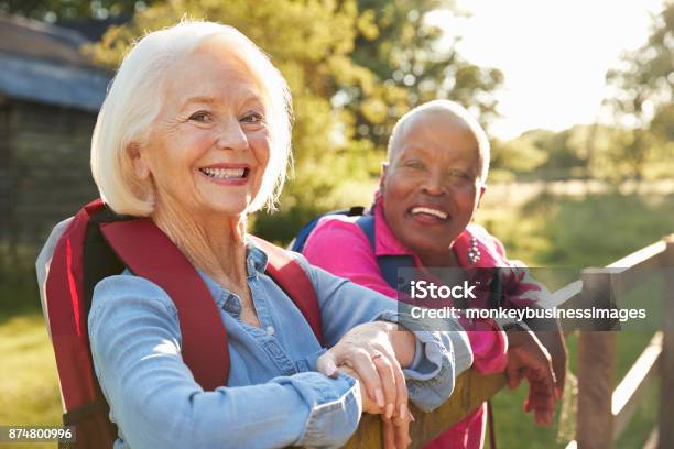 Portrait Of Two Female Senior Friends Hiking In Countryside Stock Photo - Download Image Now