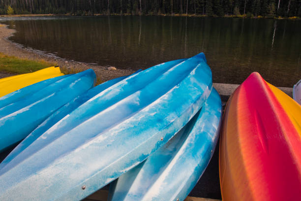 istock Colorful kayaks on a lake shore 874801002